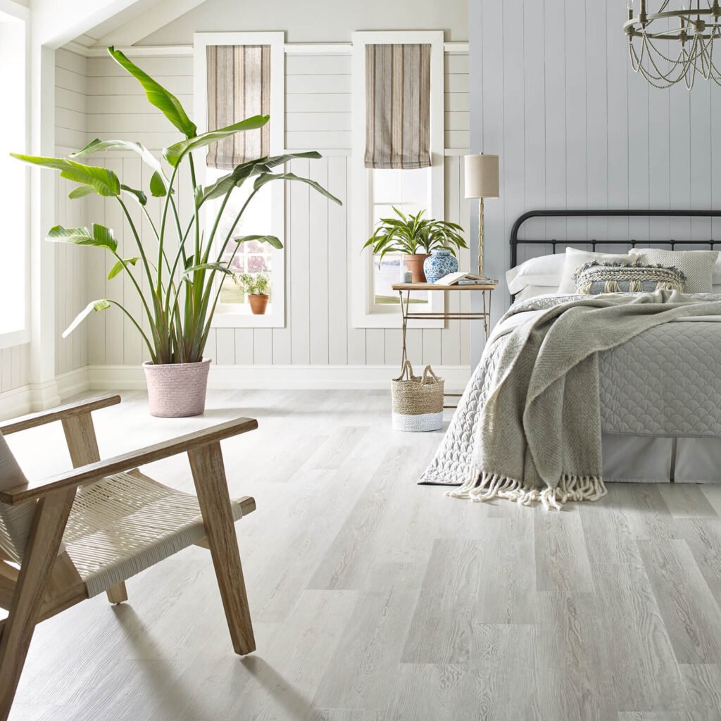 Bedroom with light gray vinyl plank flooring and wooden chair