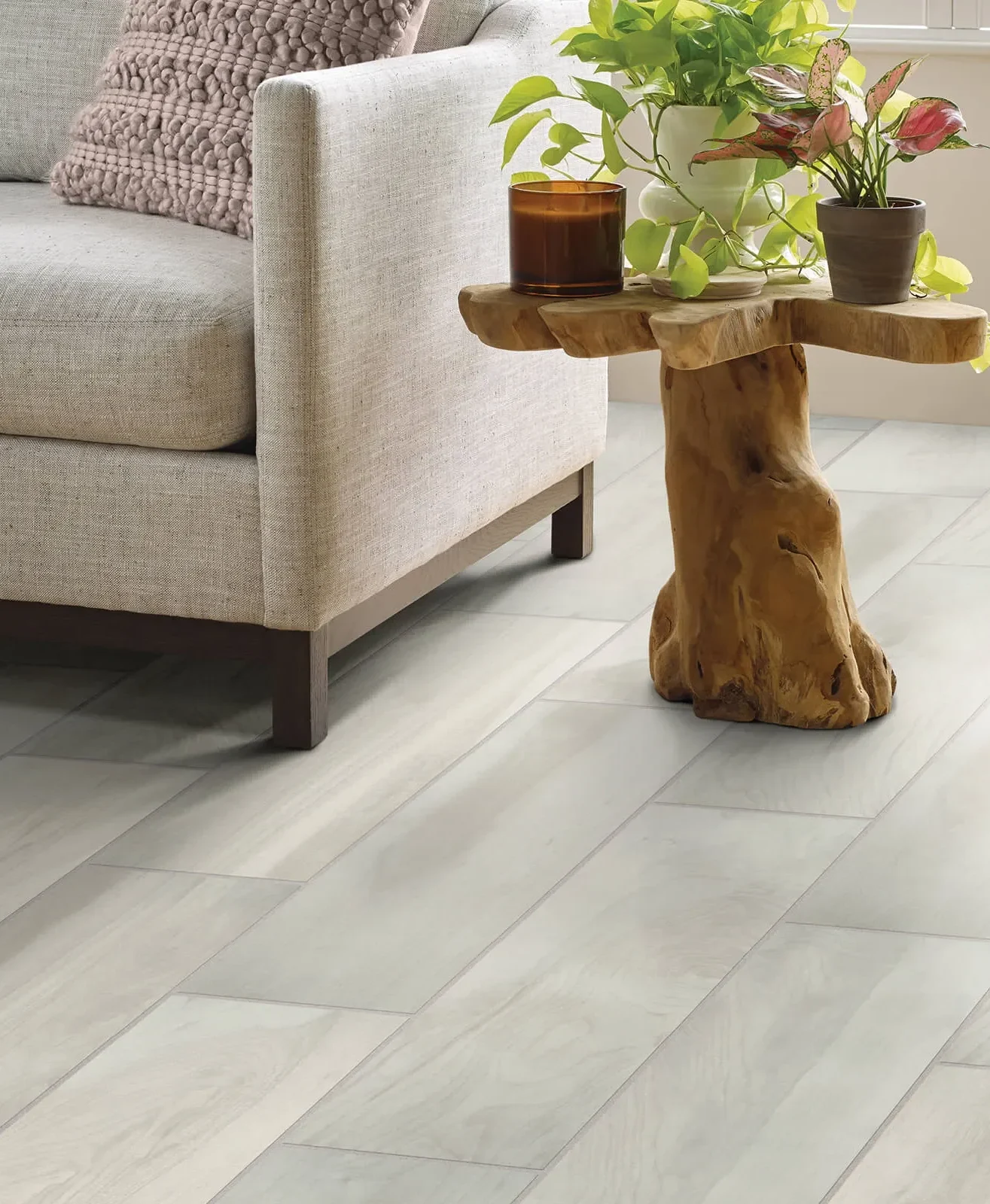 Light gray tile flooring with beige sofa and rustic wooden side table